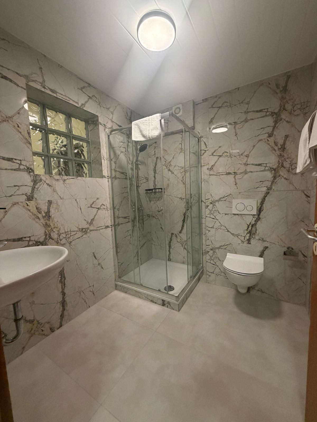 Bathroom in marble look with glass block wall at Hotel Weller Riedstadt