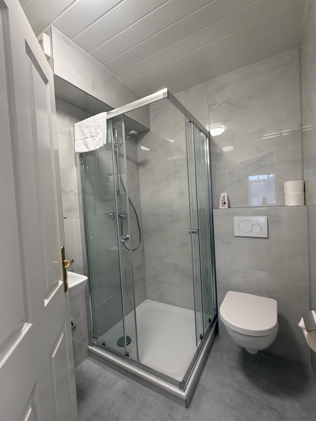 Bright bathroom in marble look with large glass shower at Hotel Weller Riedstadt