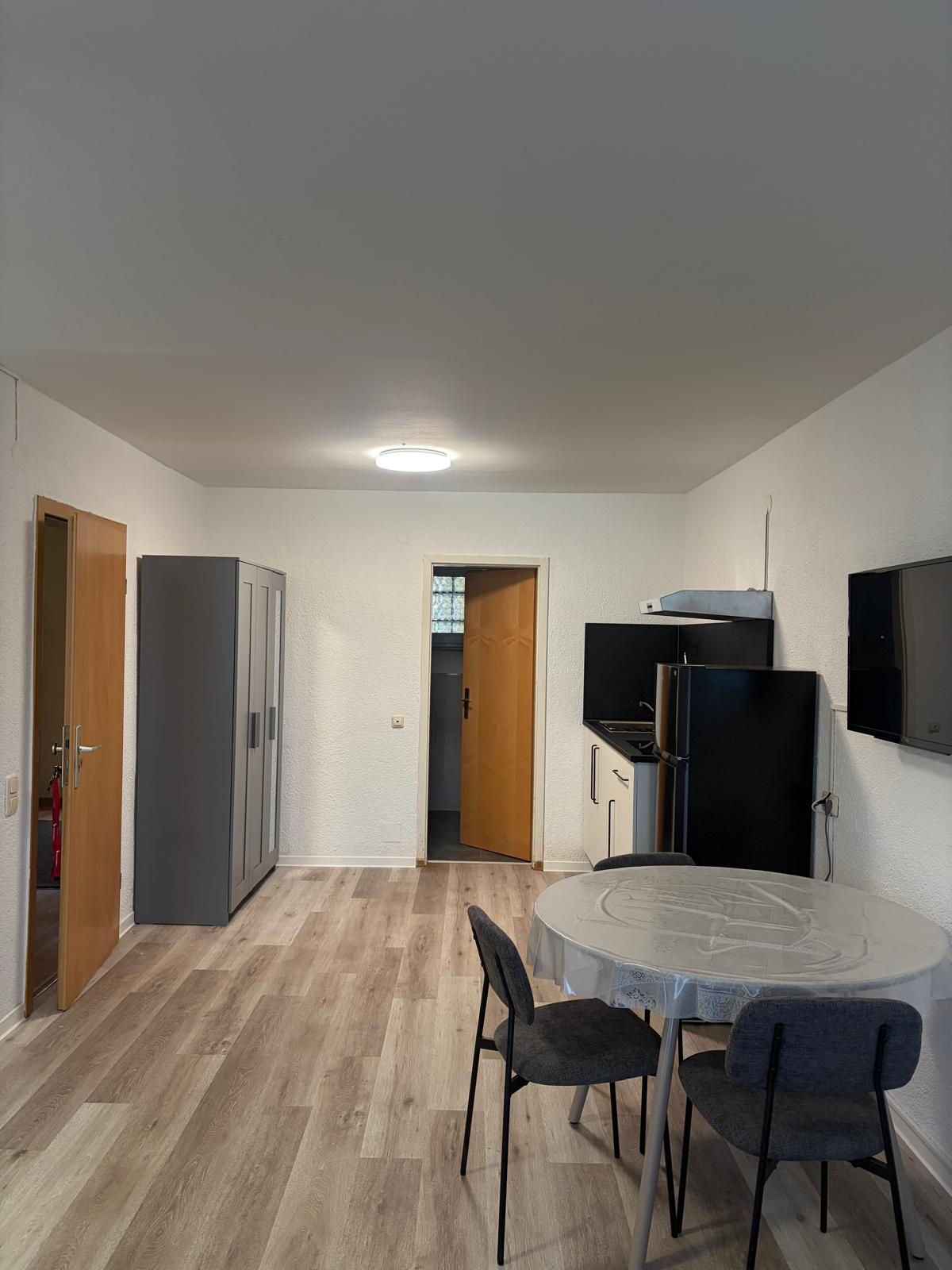 Apartment with black kitchenette and round dining table at Hotel Weller Riedstadt