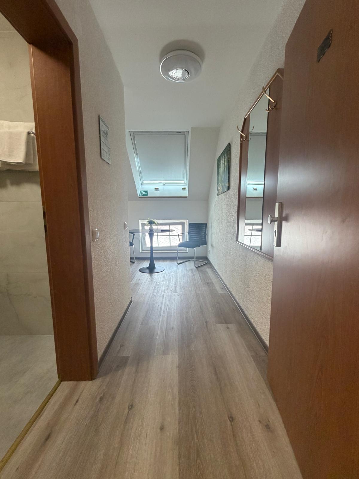 Room hallway with mirror, table and skylight at Hotel Weller Riedstadt